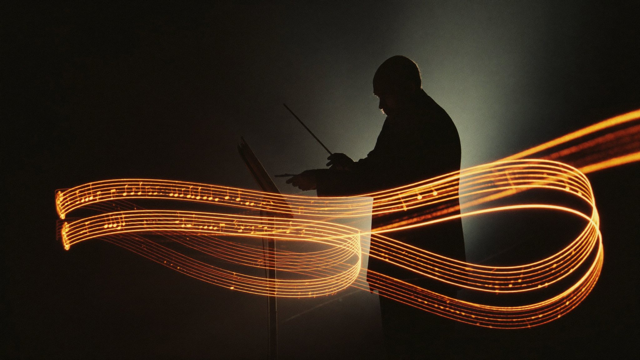 Maestro regendo fluxos de luz laranja como partitura